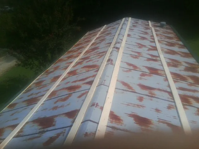 Rusted metal roof panels with new wood purlins before replacement — Storm Damage Roof Repair in Shelby by Roofing Brothers