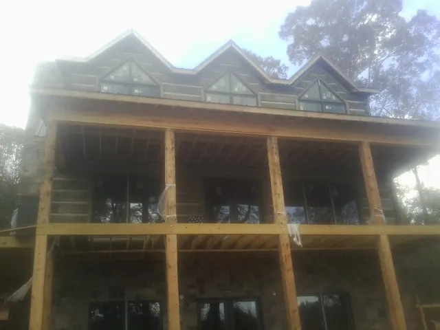 Dormers and porch framing on a large log home under construction in Shelby