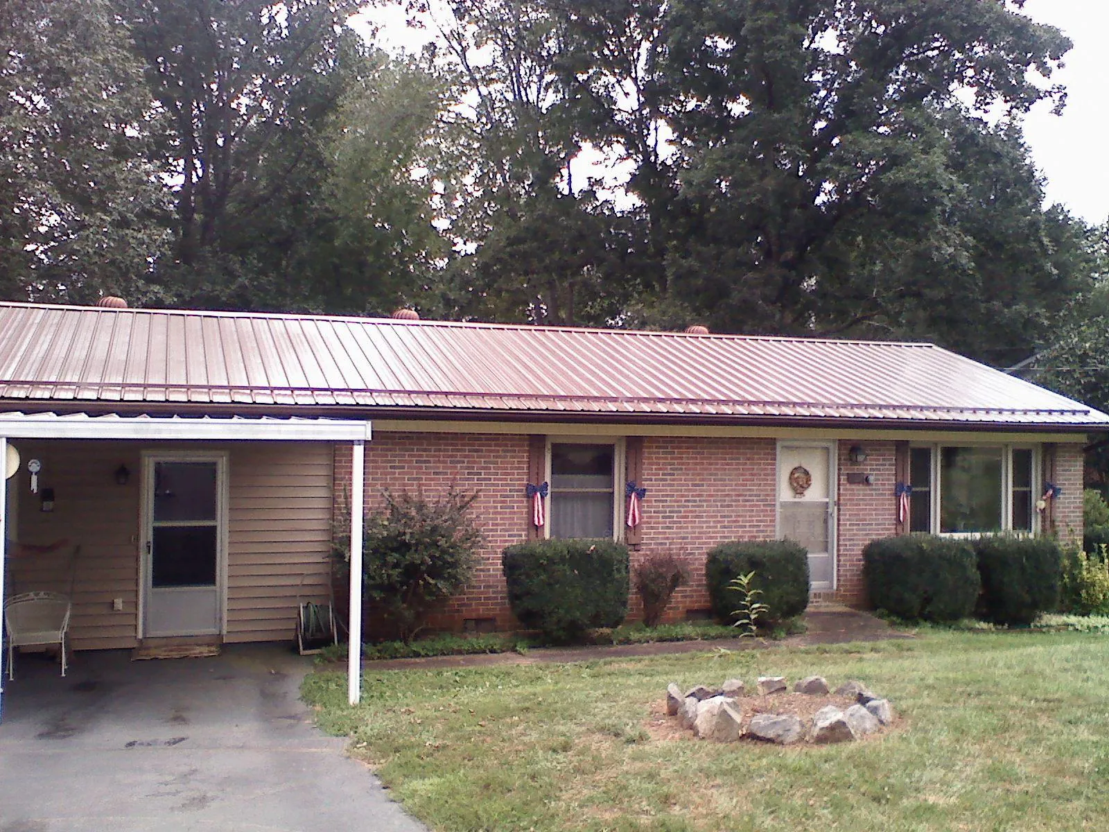 Bronze metal roof and carport on a brick ranch home — Roof Repair work by our crew in Shelby