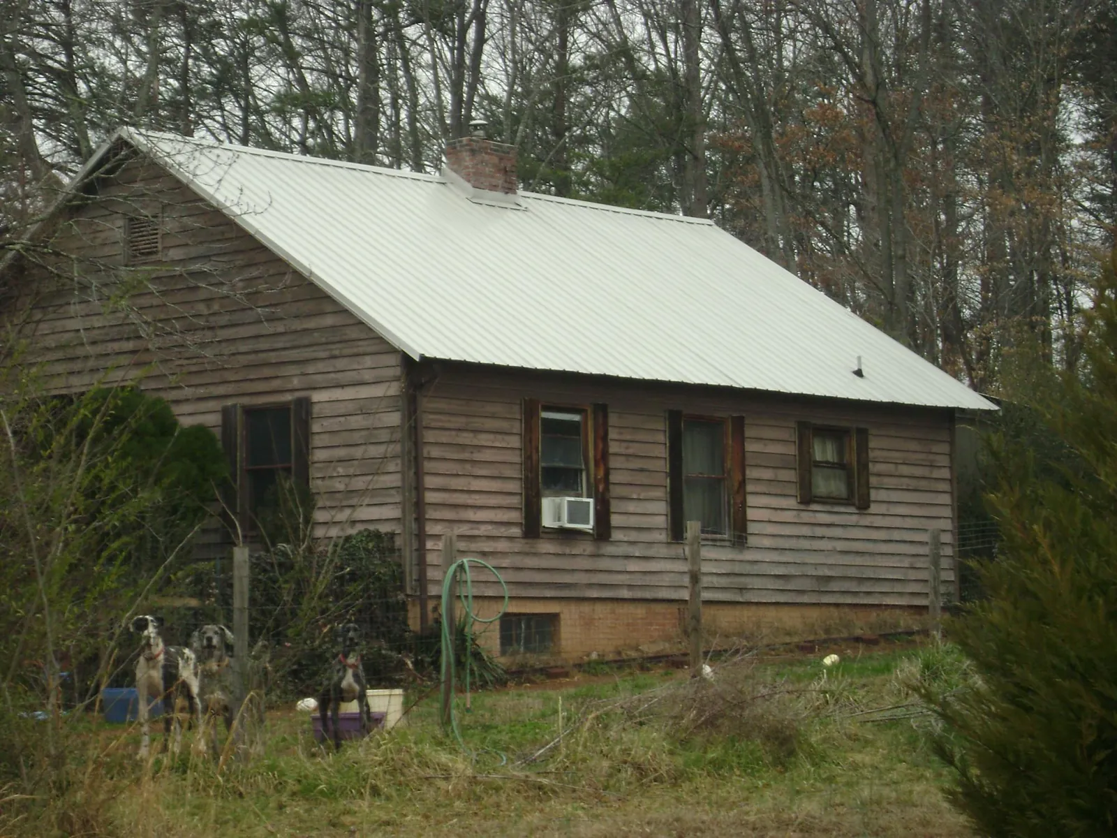 White metal roof on an old wood sided farmhouse, from a Metal Roof Installation job in Shelby